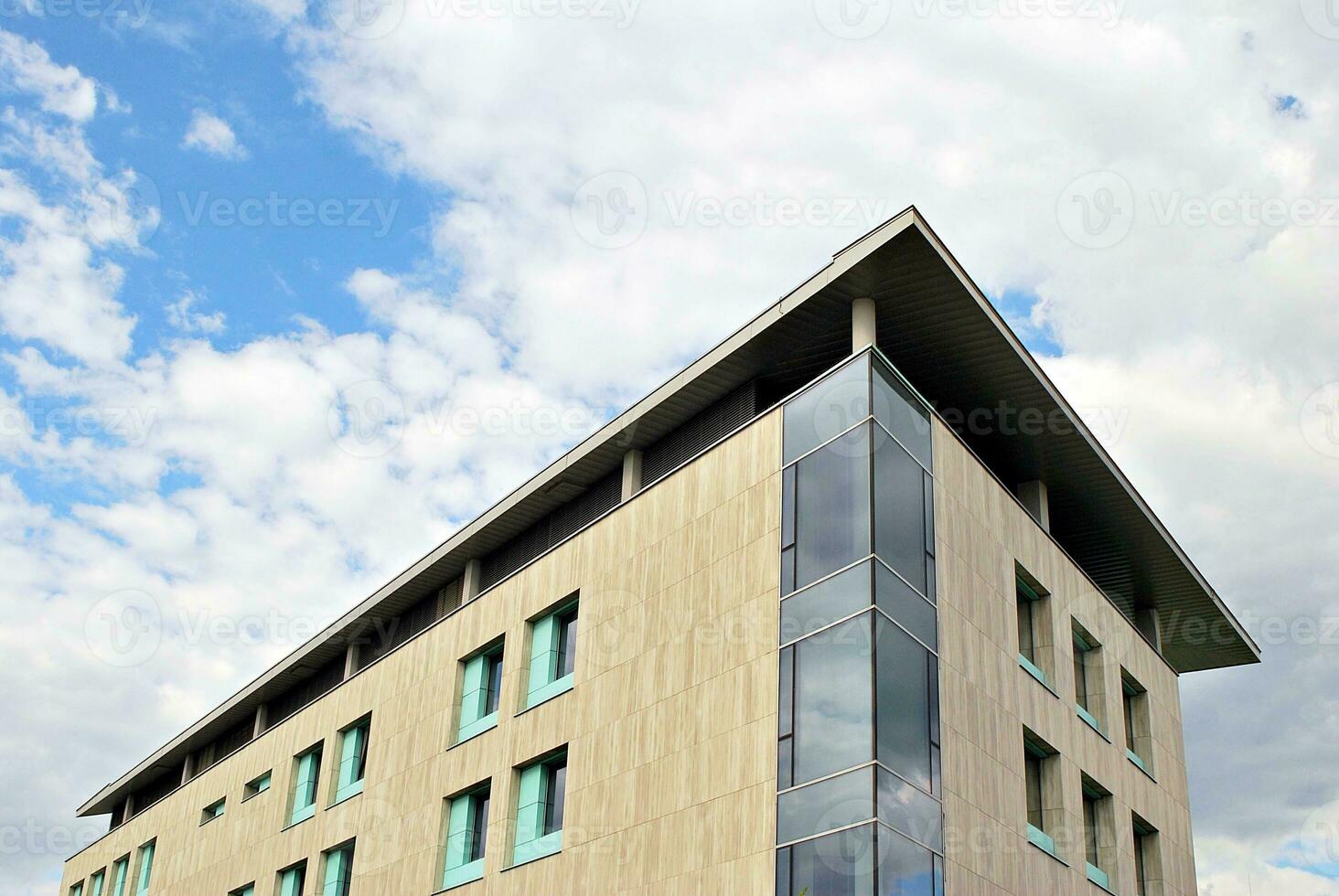 Abstract closeup of the glass-clad facade of a modern building covered in reflective plate glass. Architecture abstract background. Glass wall and facade detail. photo