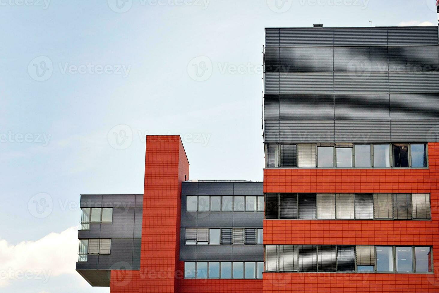 Abstract closeup of the glass-clad facade of a modern building covered in reflective plate glass. Architecture abstract background. Glass wall and facade detail. photo