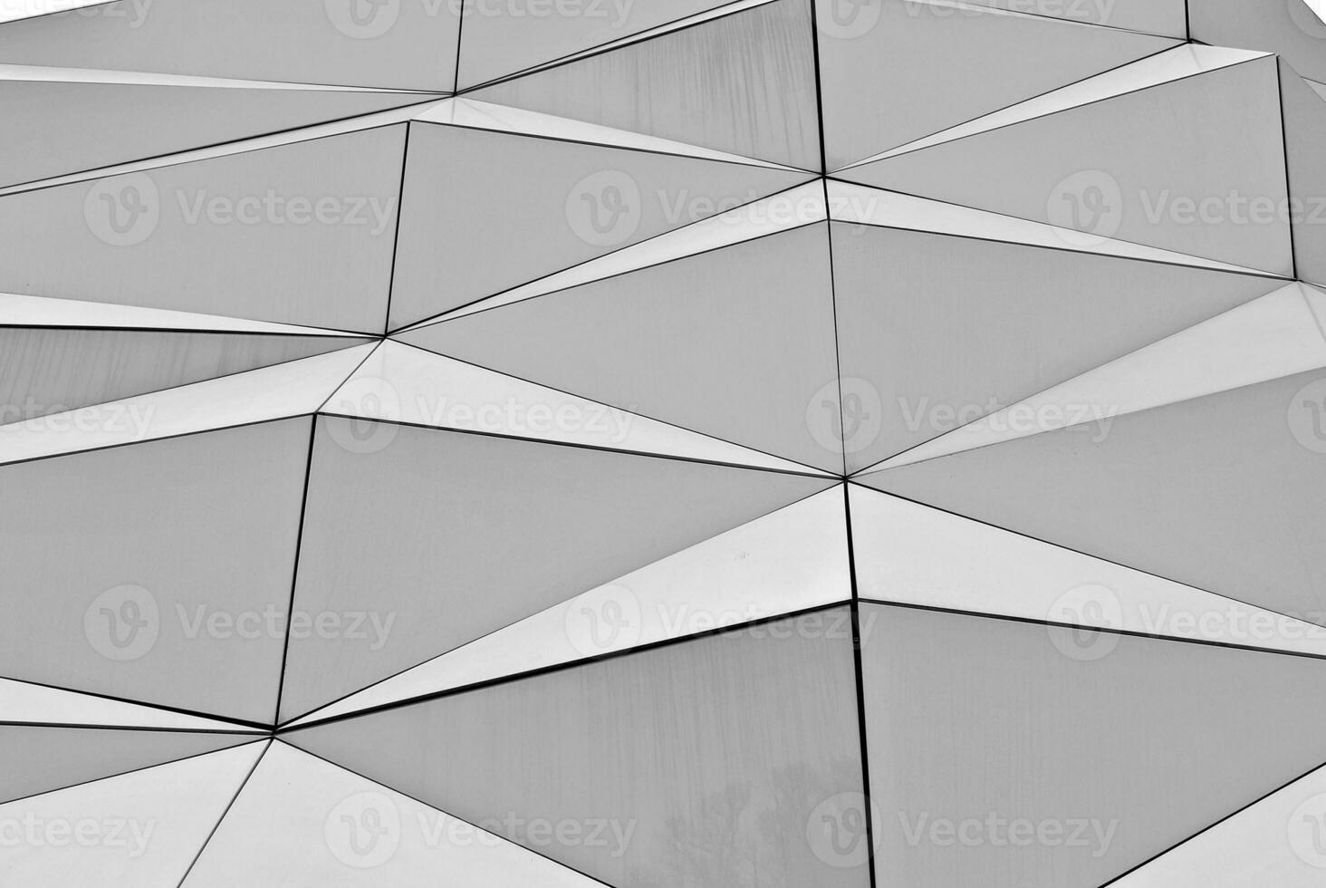 Abstract closeup of the glass-clad facade of a modern building covered in reflective plate glass. Architecture abstract background. Glass wall and facade detail. photo