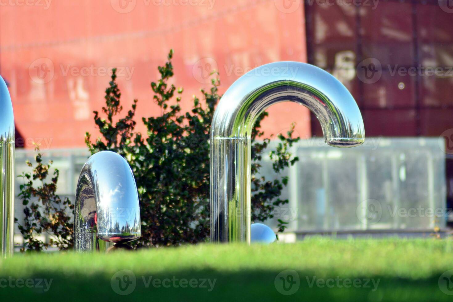 Public art installation in front modern building.Decorative stainless steel pipes photo