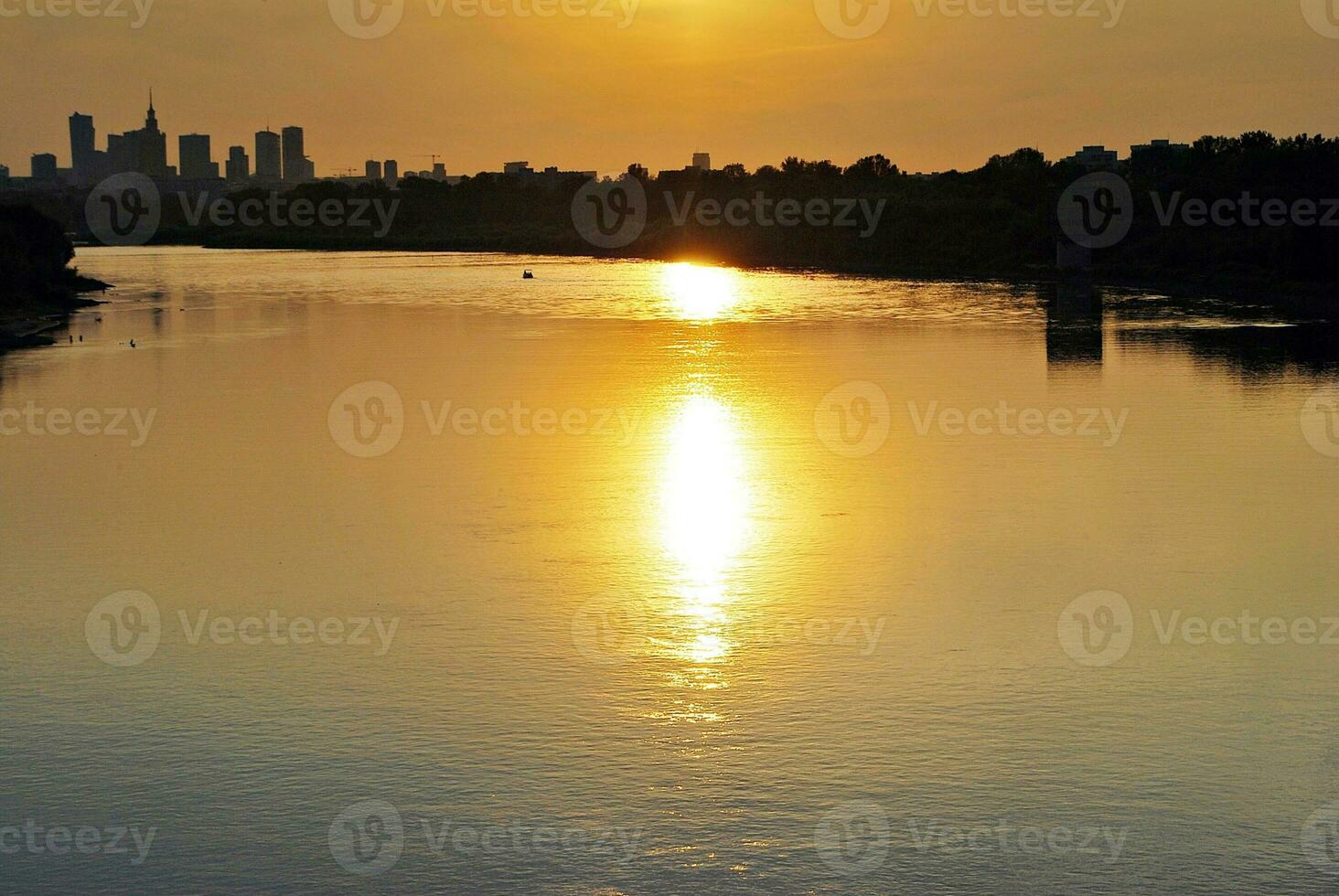 River in the city in at colorful sunset in the background photo