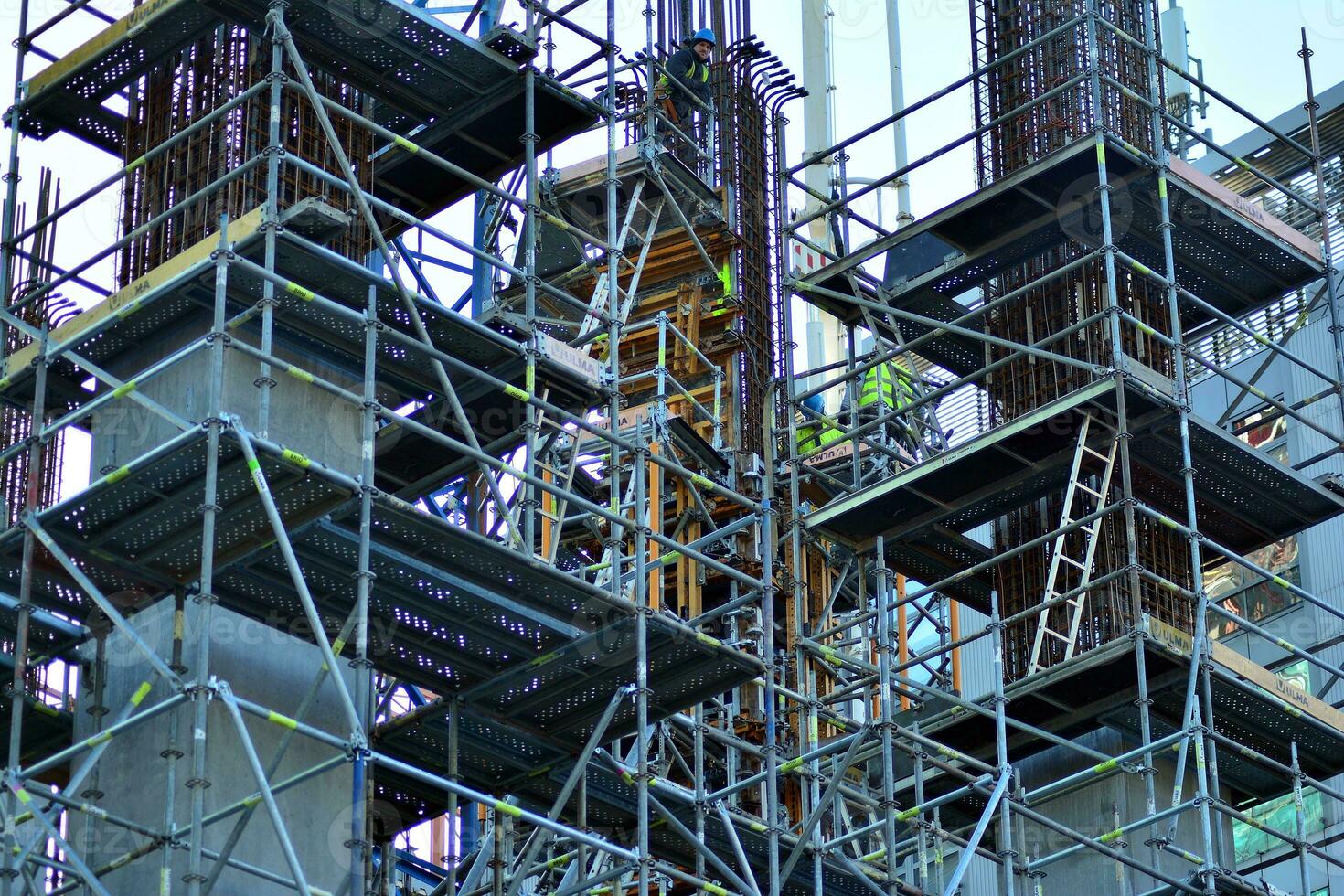 High rise building under construction. Installation of glass facade panels on a reinforced concrete structure. photo