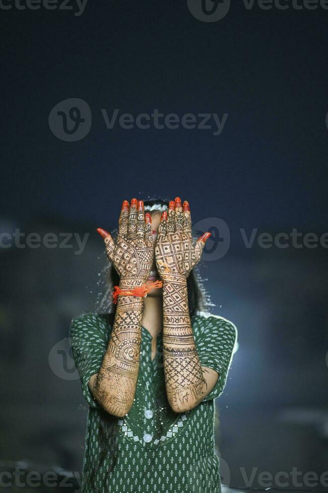 un hermosa obra de arte alheña en el mano de un indio novia con herbario heena en mojado condición foto
