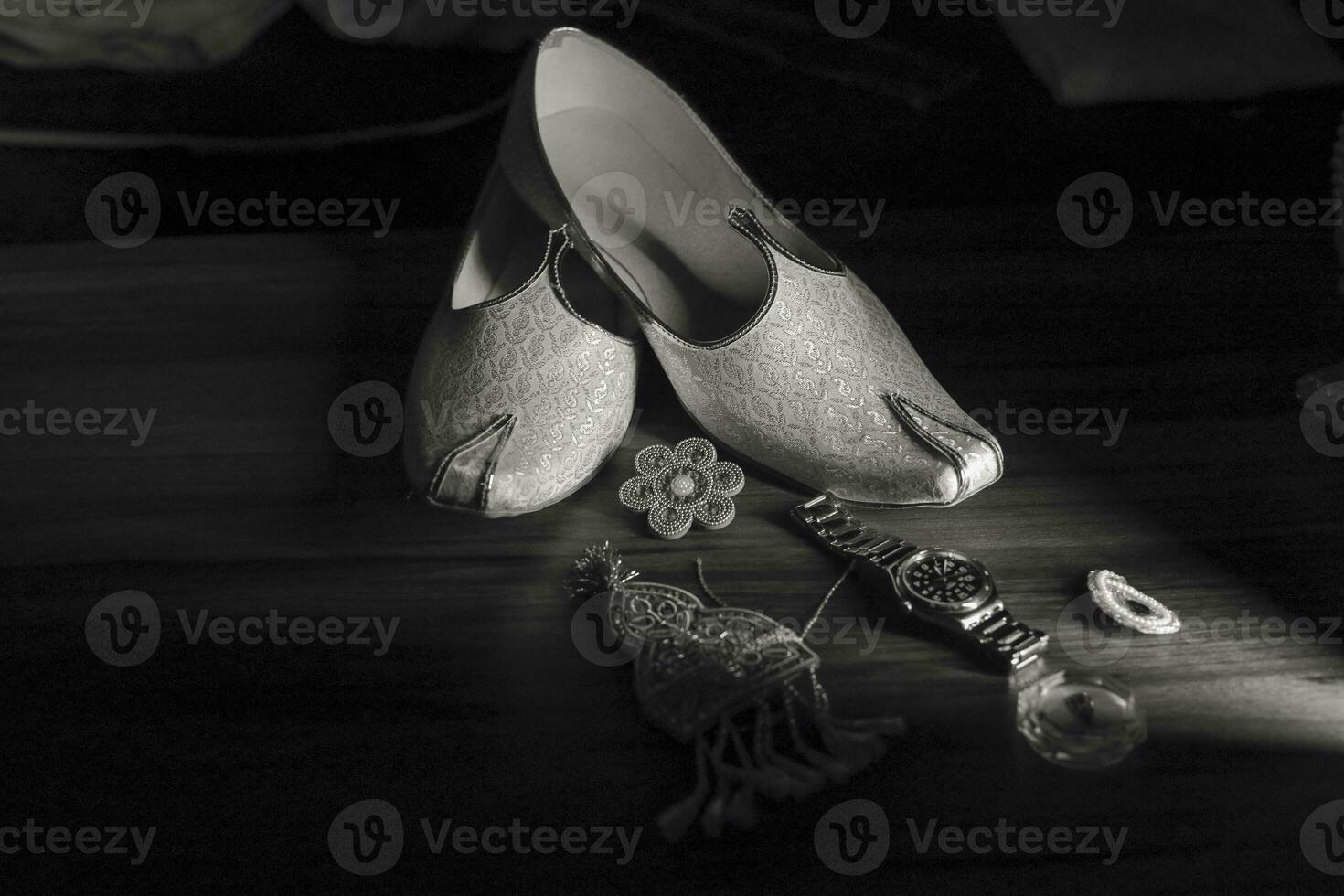 Indian groom's traditional wedding jewelry and shoes close up photo