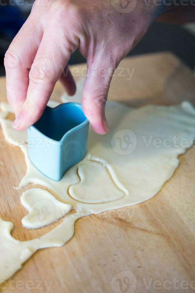 Baking heart shaped cookies for Valentine day photo