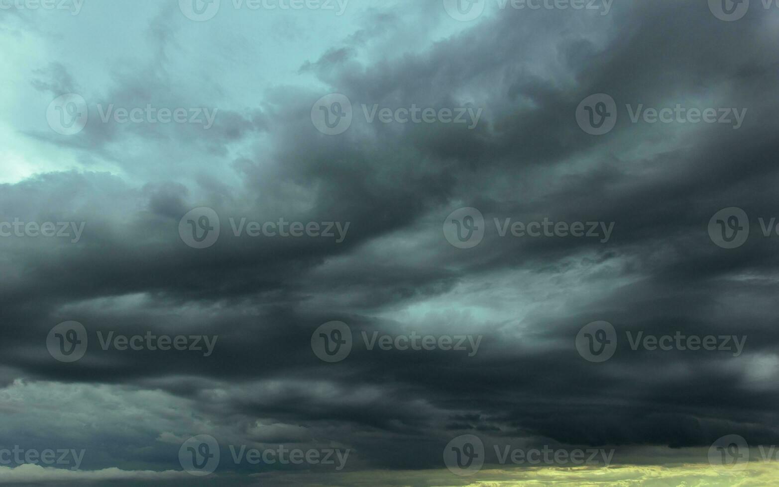 The dark sky with heavy clouds converging and a violent storm before the rain.Bad or moody weather sky and environment. carbon dioxide emissions, greenhouse effect, global warming, climate change. photo