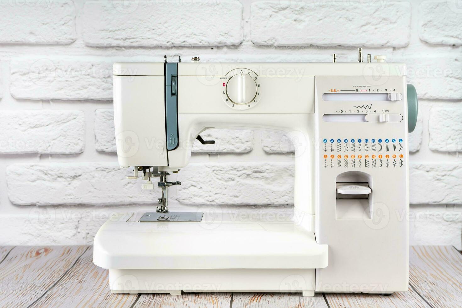 Modern sewing machine on table in tailor's workshop photo