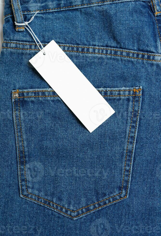 Back side pocket of blue jeans pants and price tag close-up background, mockup, copy space photo