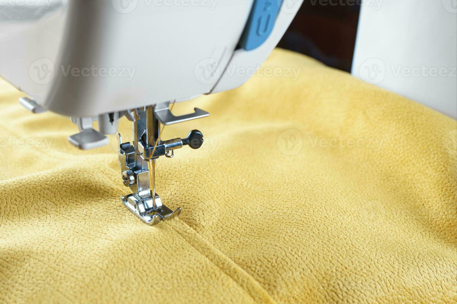 moderno de coser máquina con amarillo terciopelos tela cerca arriba foto