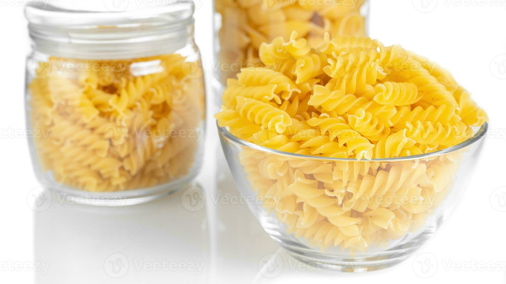 Raw pasta in bowl isolated on white background photo