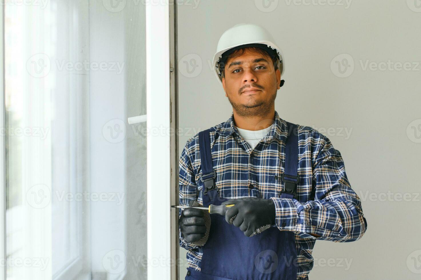 indio Servicio hombre instalando ventana con destornillador foto