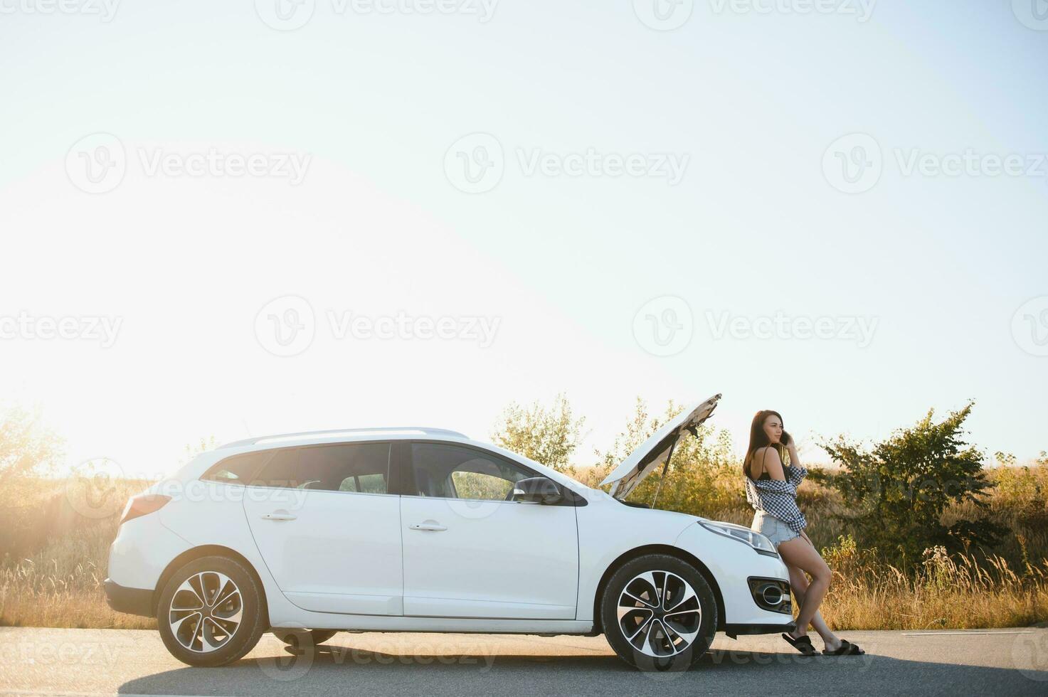 Beautiful sexy woman near a broken car. Confused woman does not know what to do photo