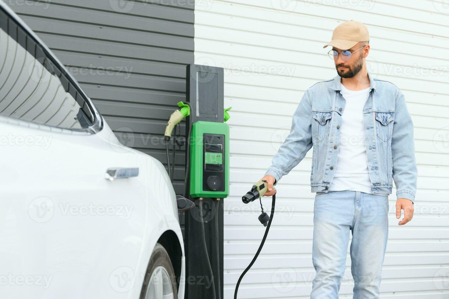 Man standing by his electric car photo