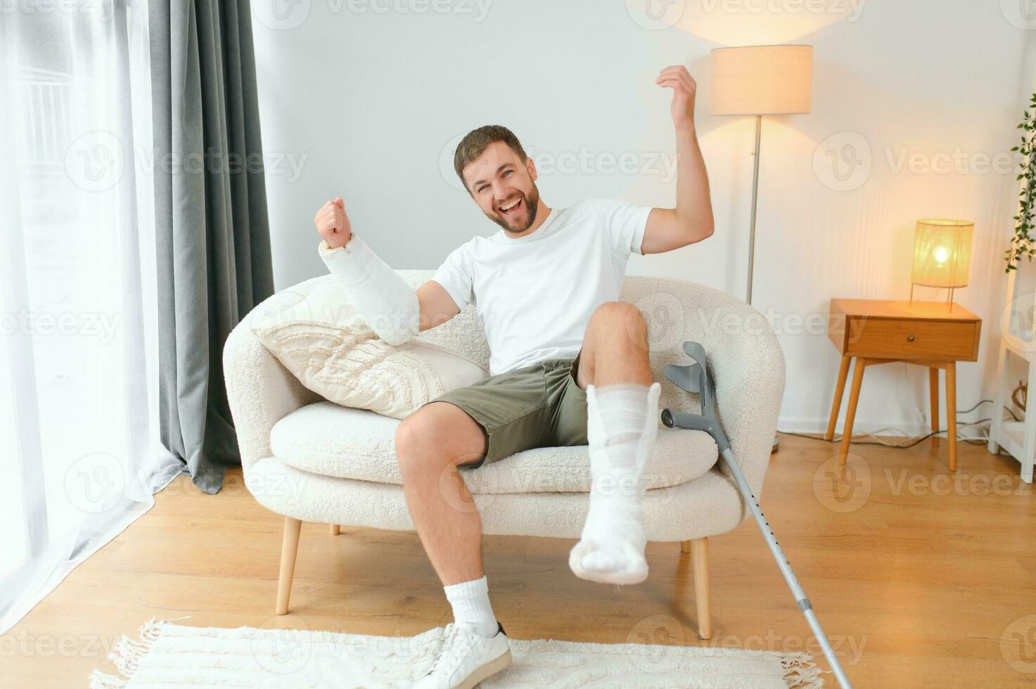 Happy man recovery from accident fracture broken bone injury with leg and arm. Social security and health insurance concept photo