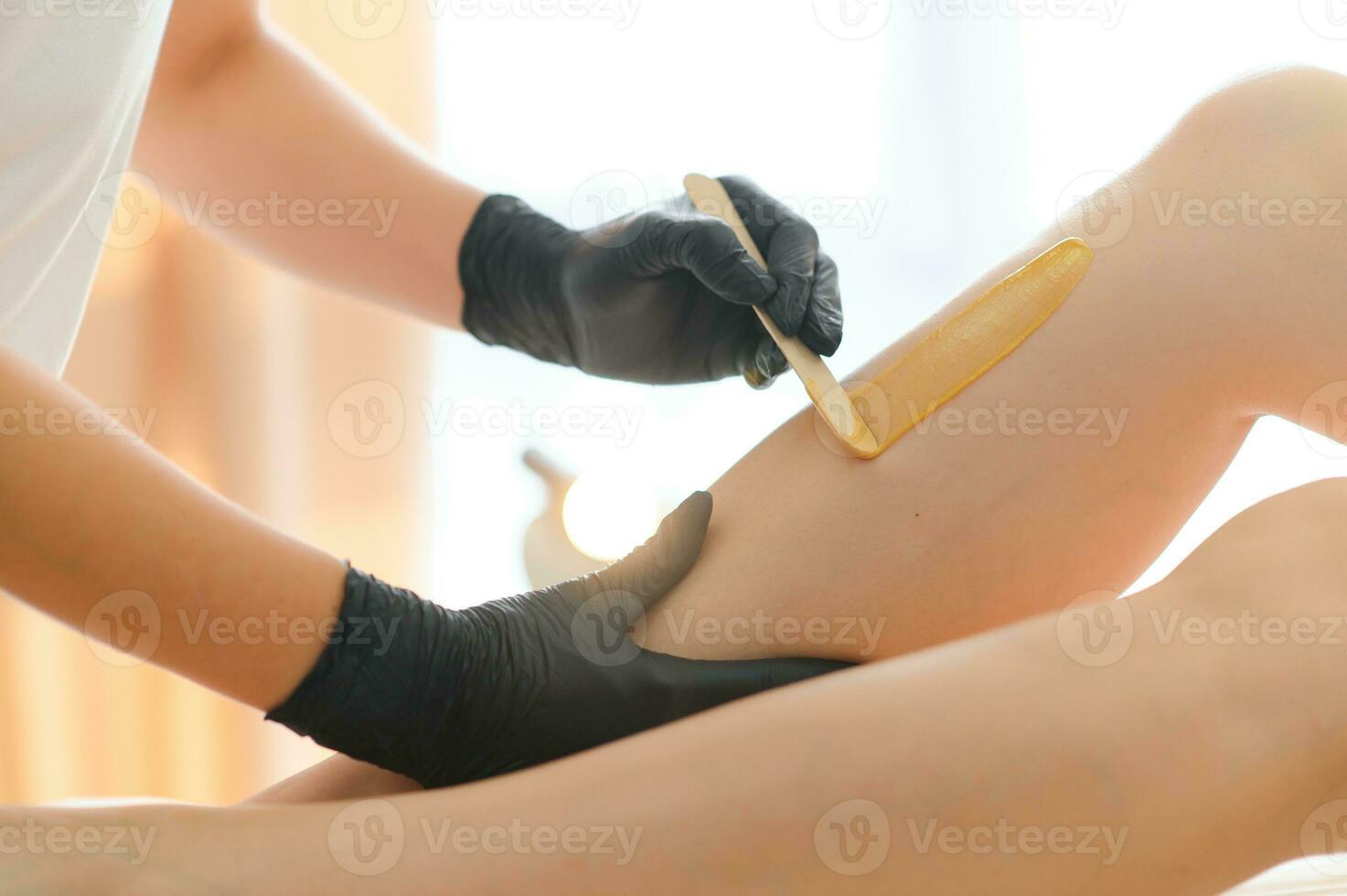 Sugaring epilation skin care with liquid sugar at legs close-up. Beauty and cosmetology concept. photo