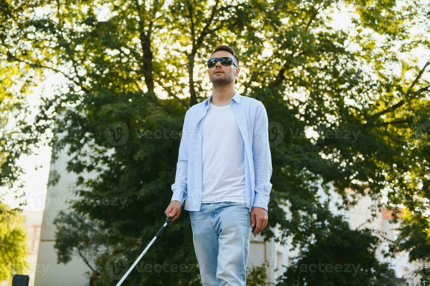 Blind man. Visually impaired man with walking stick, photo