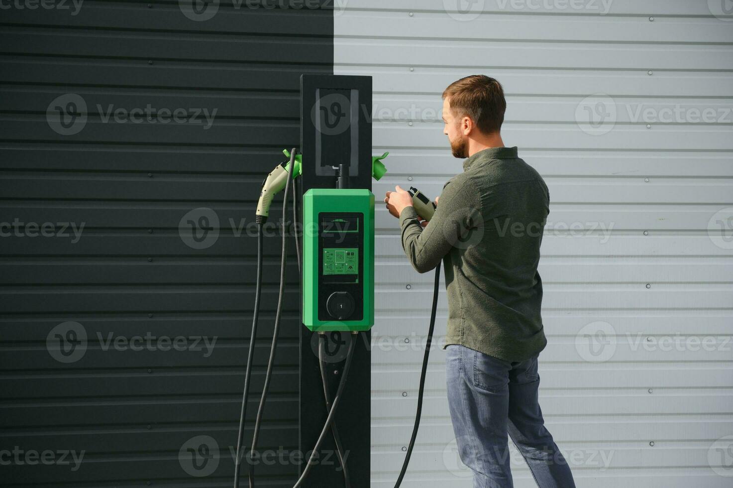 a man charges an electric car photo