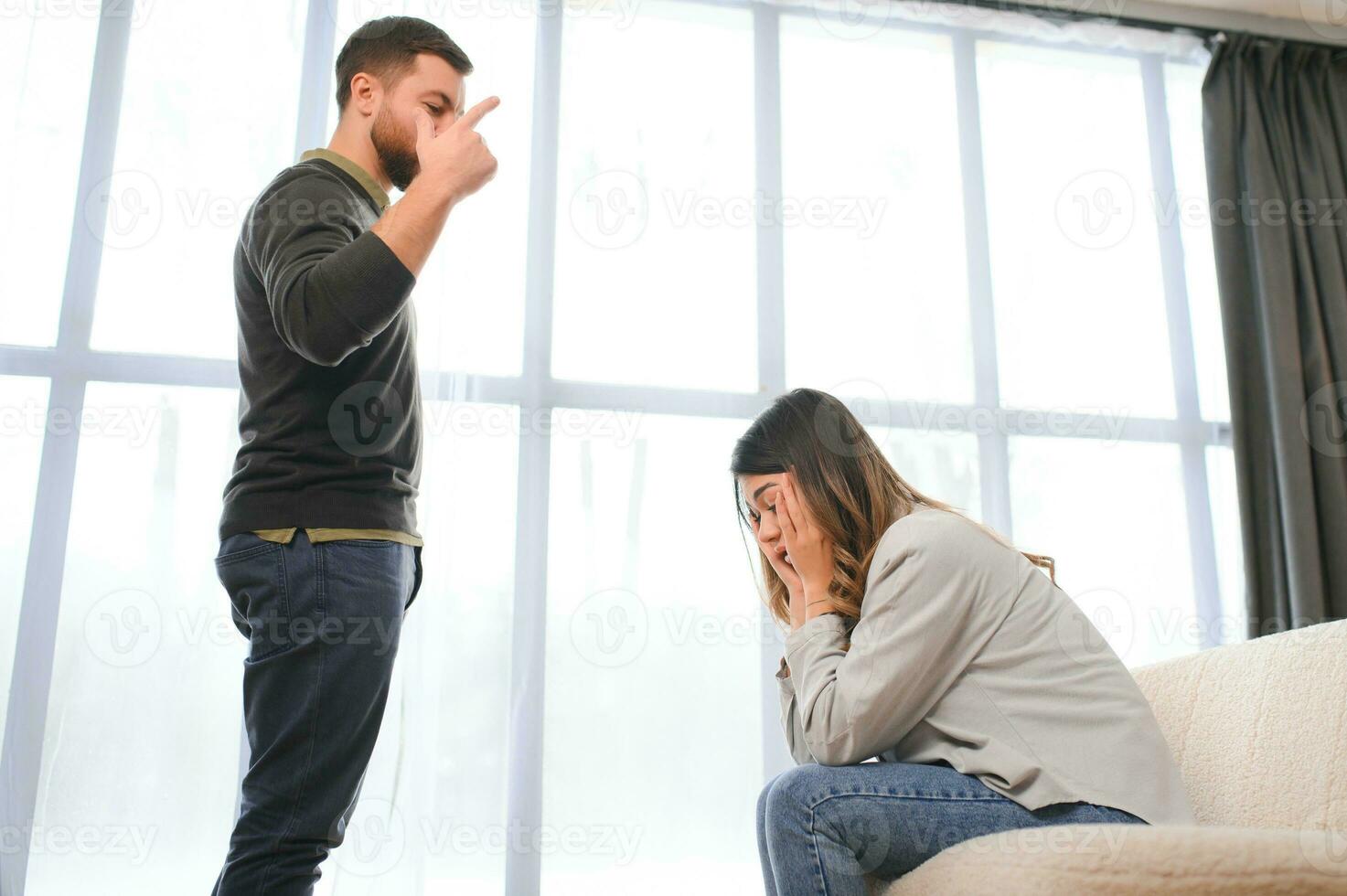 Irritated husband is shouting at his wife with violence. Woman is covering her face with fear photo