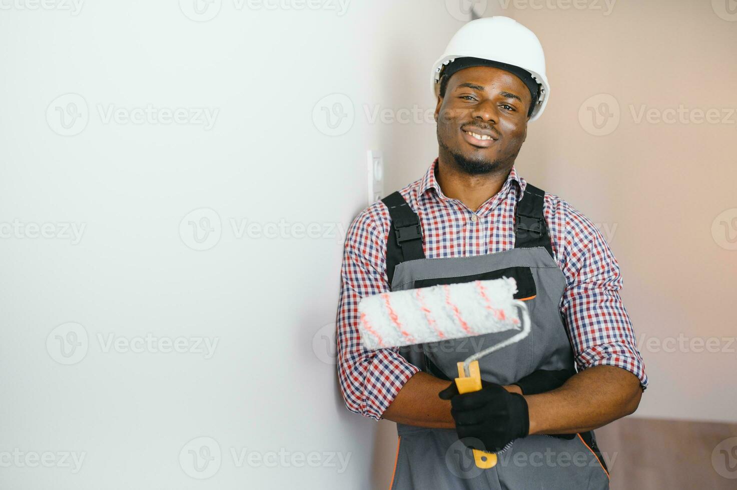 African-American painter doing repair in room photo