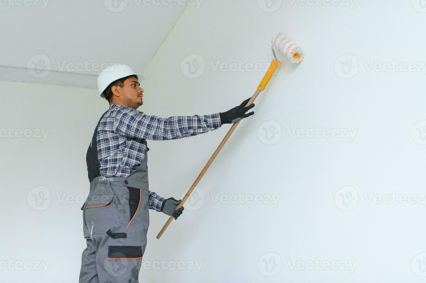 Indian worker makes repairs in an apartment photo