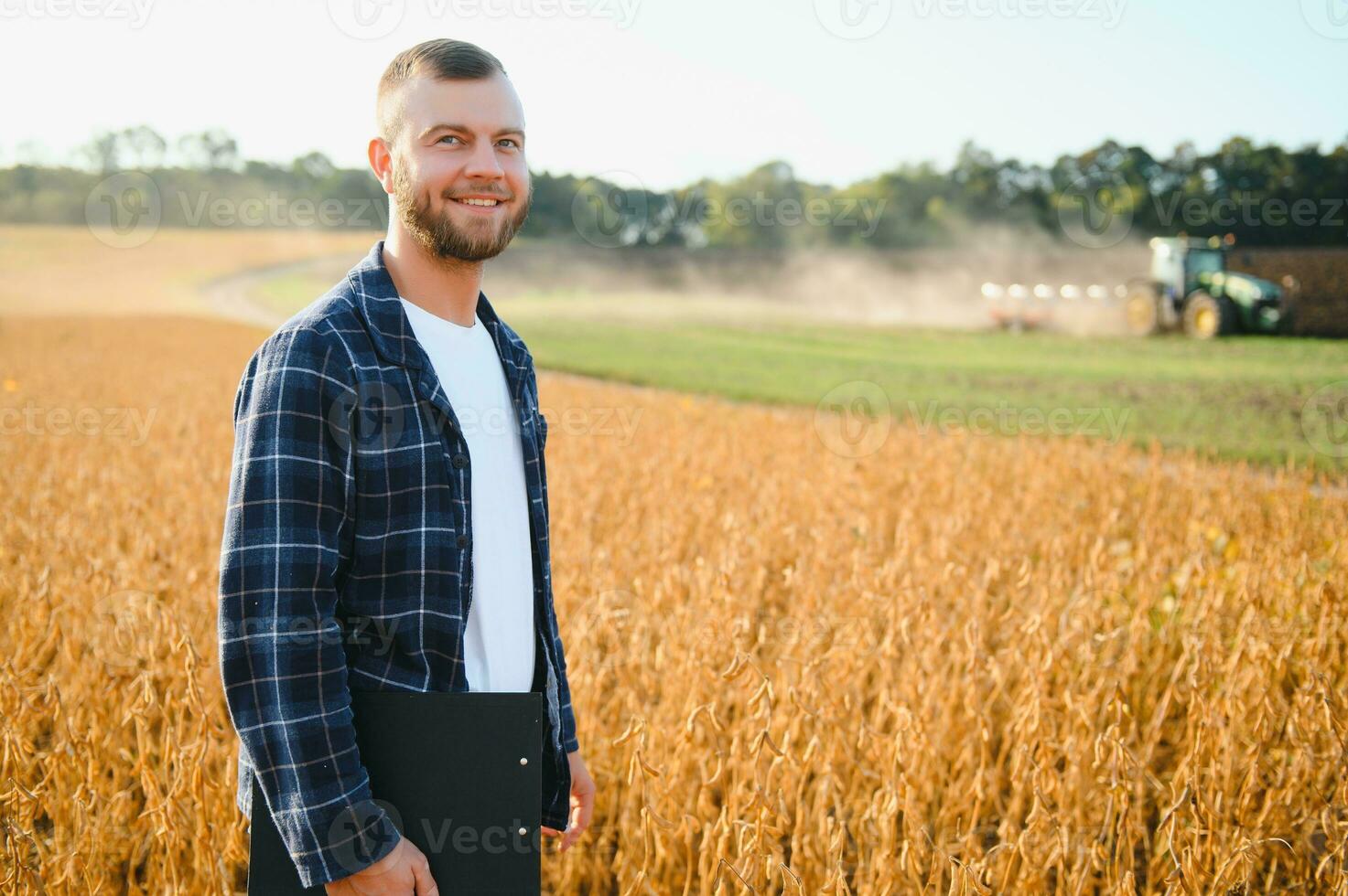 farmer agronomist in soybean field checking crops. Organic food production and cultivation photo