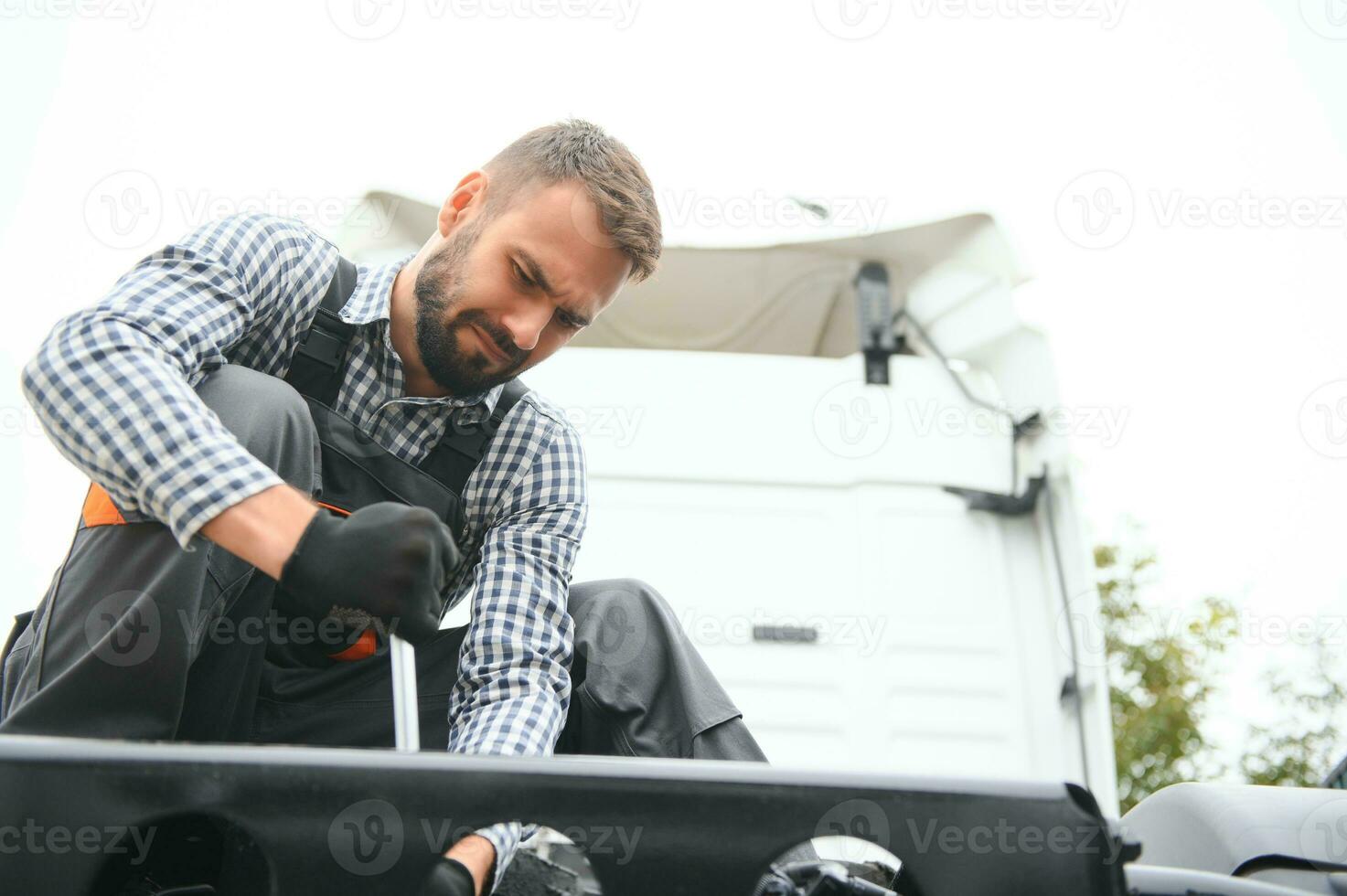 Man in uniform. Truck repair. Car malfunction. photo