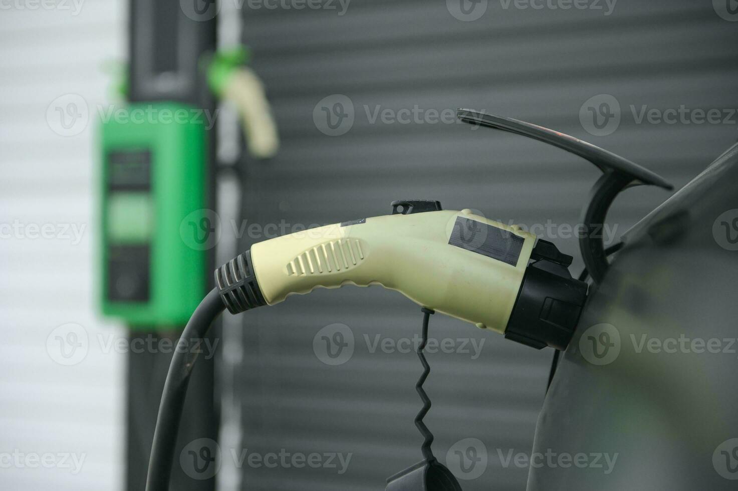 Power cable pump plug in charging power to electric vehicle EV car photo