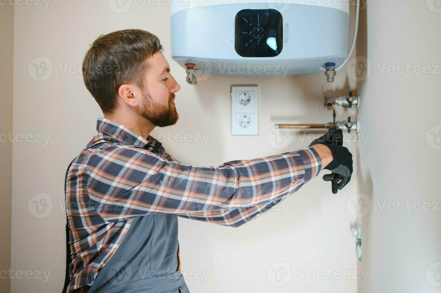 Professional plumber checking a boiler and pipes, boiler service concept photo