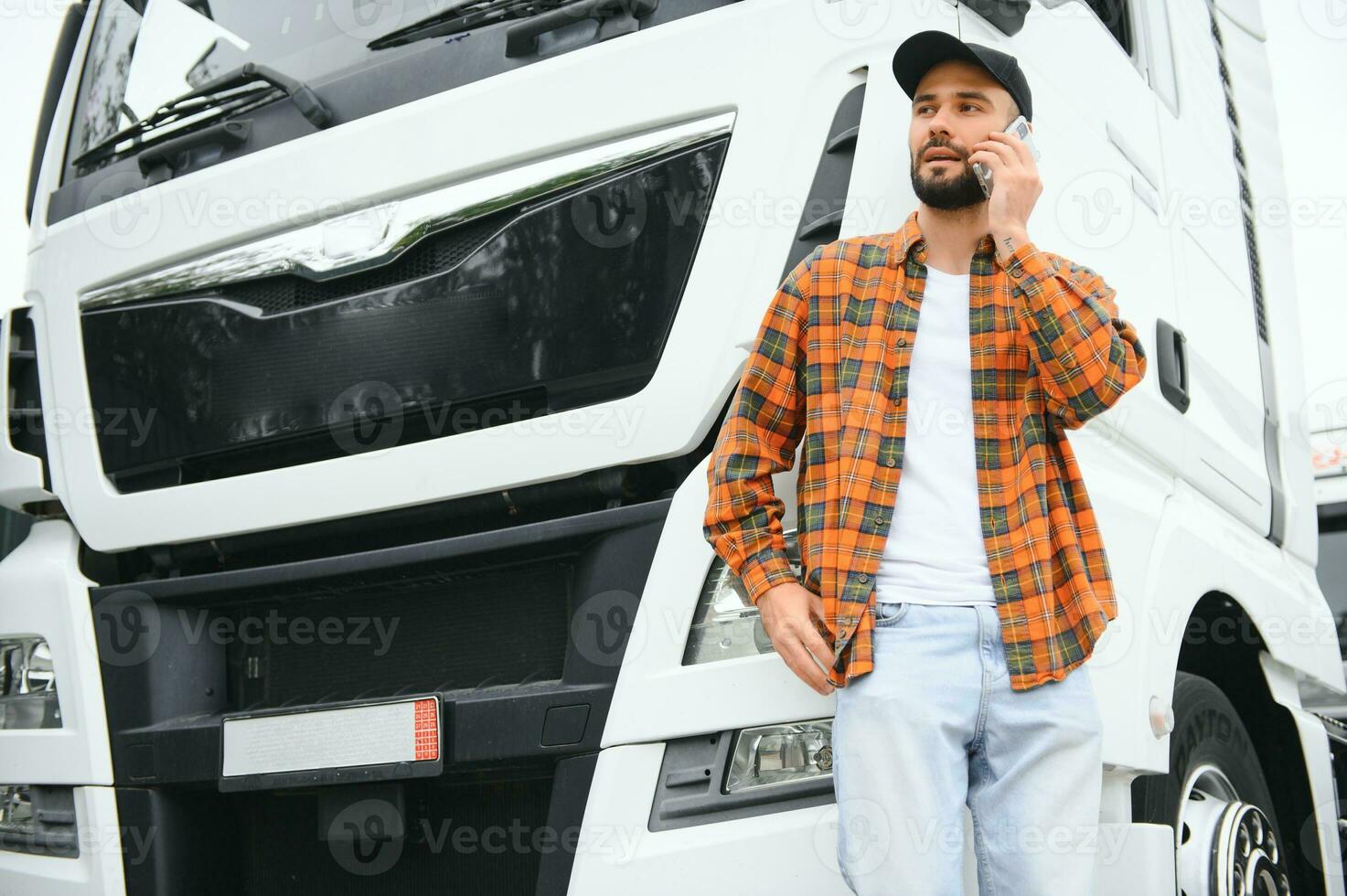 Man trucker talking on the phone by his white truck photo