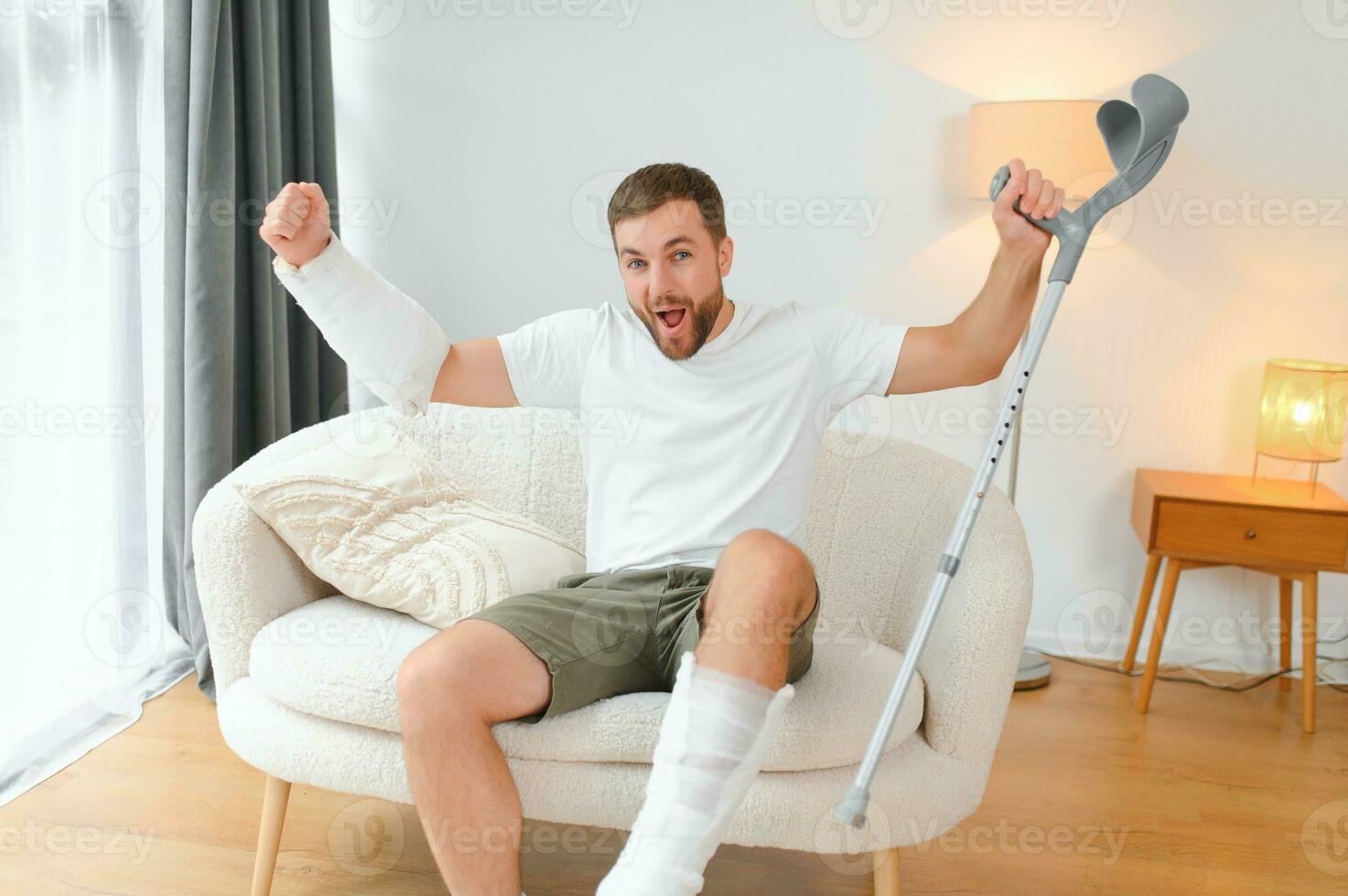 Happy man recovery from accident fracture broken bone injury with leg and arm. Social security and health insurance concept photo