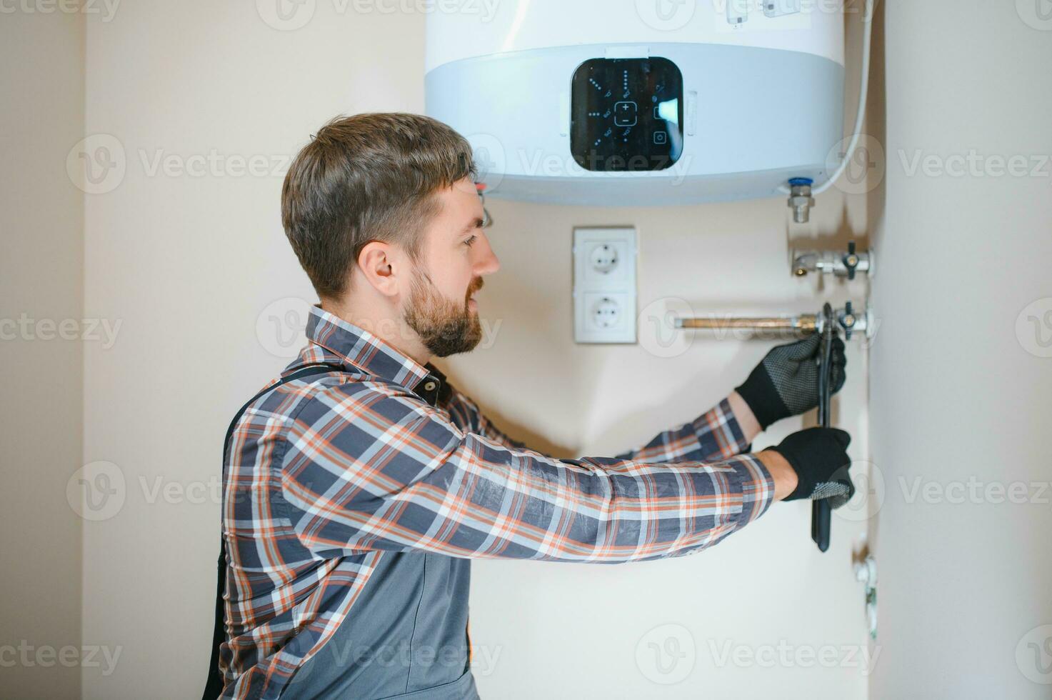 Professional plumber checking a boiler and pipes, boiler service concept photo
