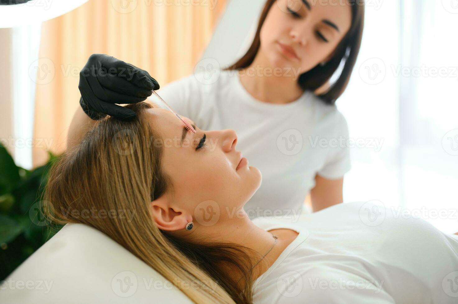 Process of creating permanent brow makeup with a machine at beauty salon photo