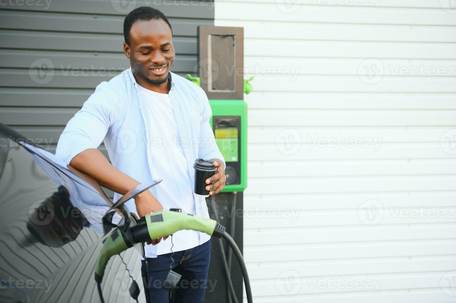 africano americano hombre cargando su eléctrico coche. foto