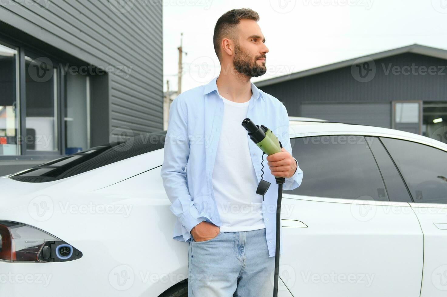 Man standing by his electric car photo