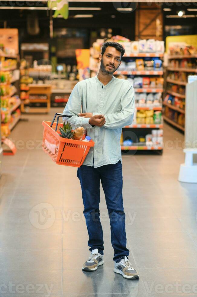 portrait of indian male in grocery with positive attitude photo