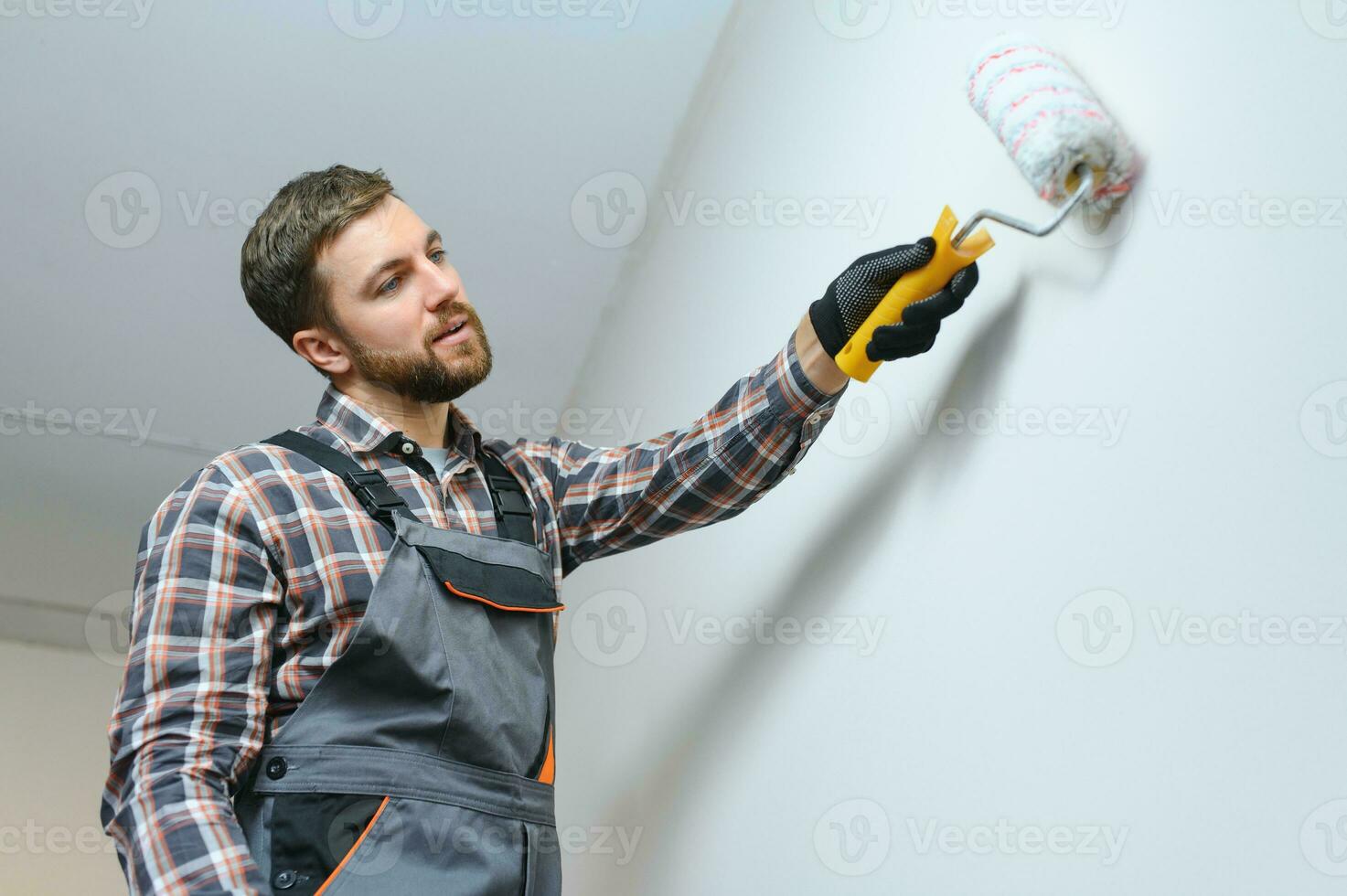 painter man painting the wall, with paint roller photo