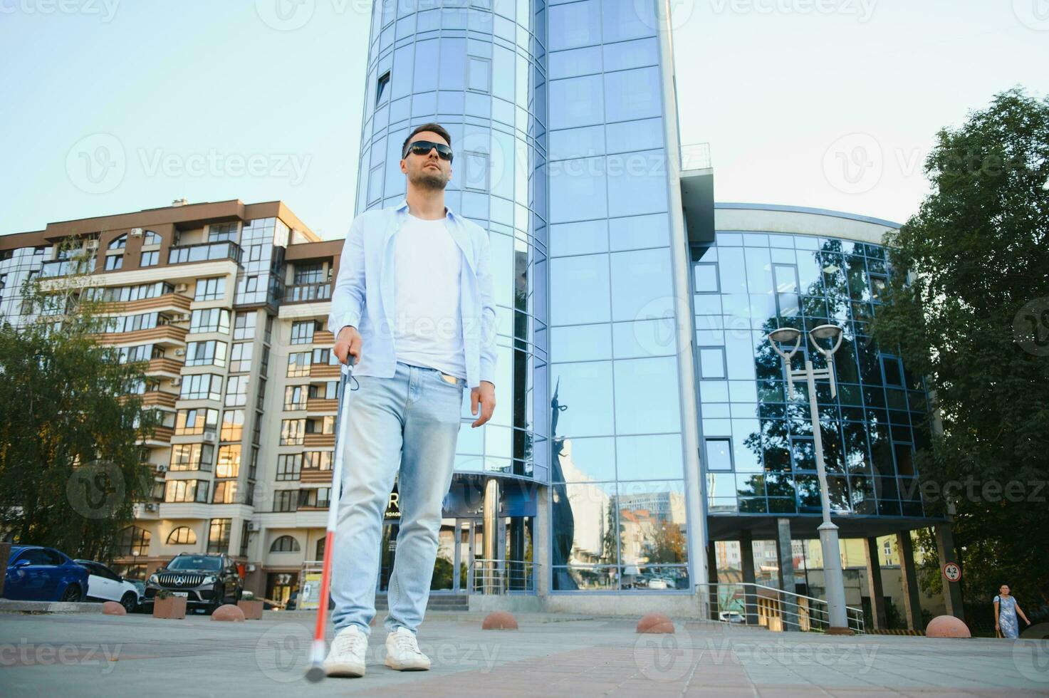 Blind Man Walking On Sidewalk Holding Stick. photo