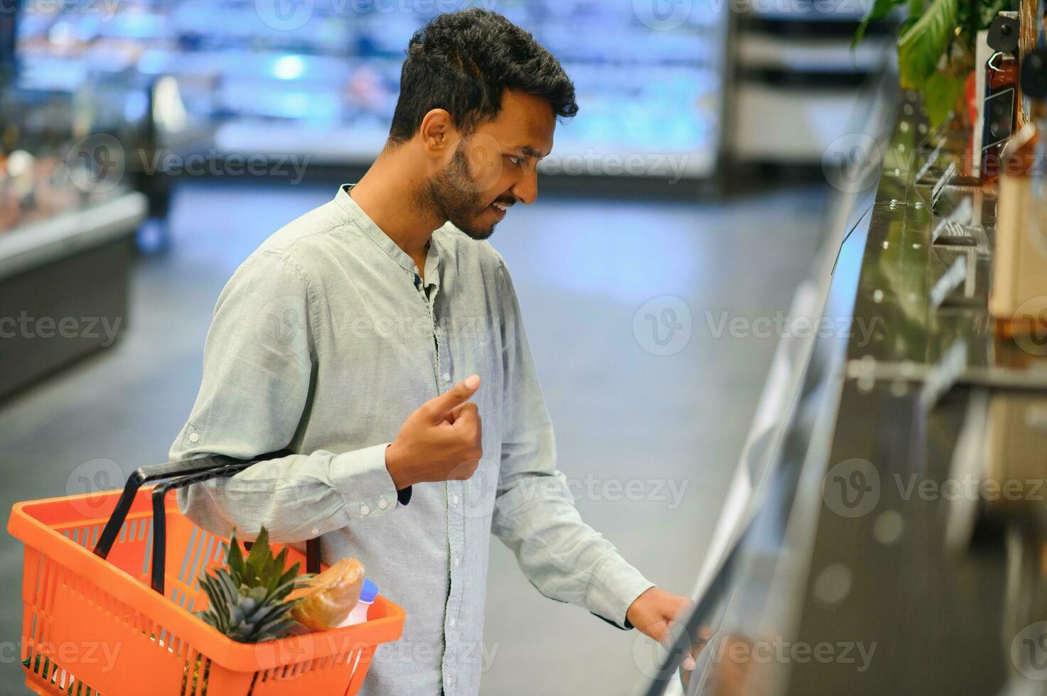 portrait of indian male in grocery with positive attitude photo