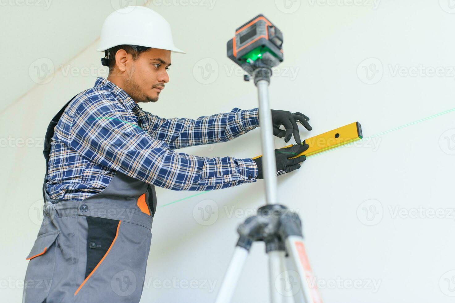 Indian worker makes repairs in an apartment photo