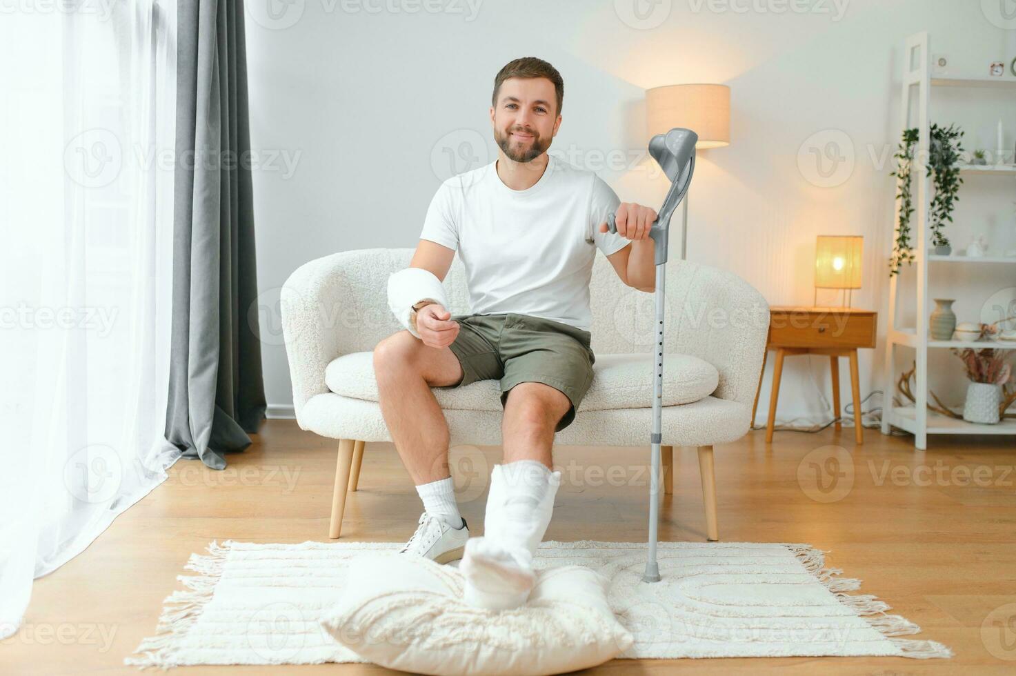 Happy man recovery from accident fracture broken bone injury with leg and arm. Social security and health insurance concept photo