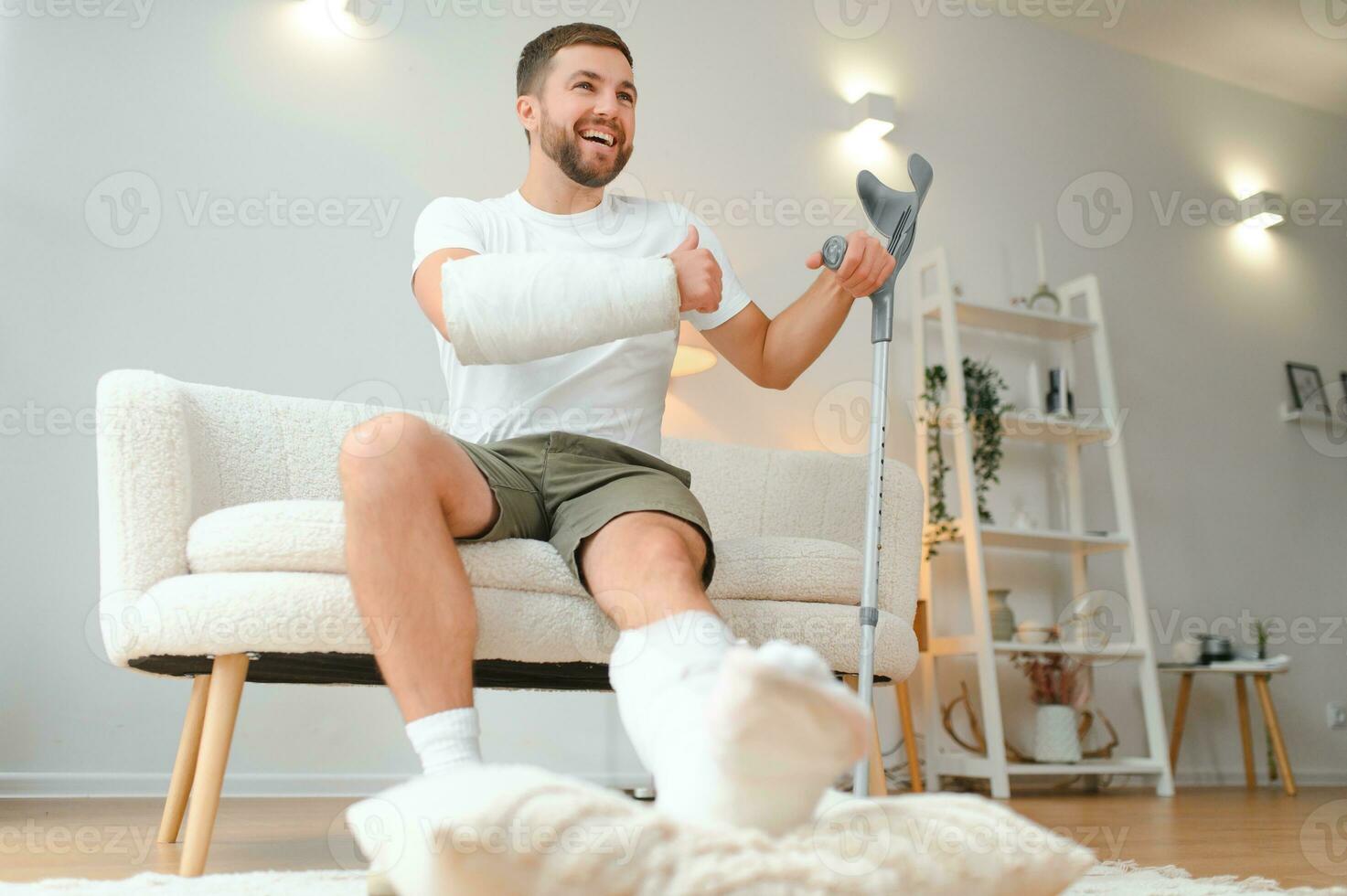 Happy man recovery from accident fracture broken bone injury with leg and arm. Social security and health insurance concept photo
