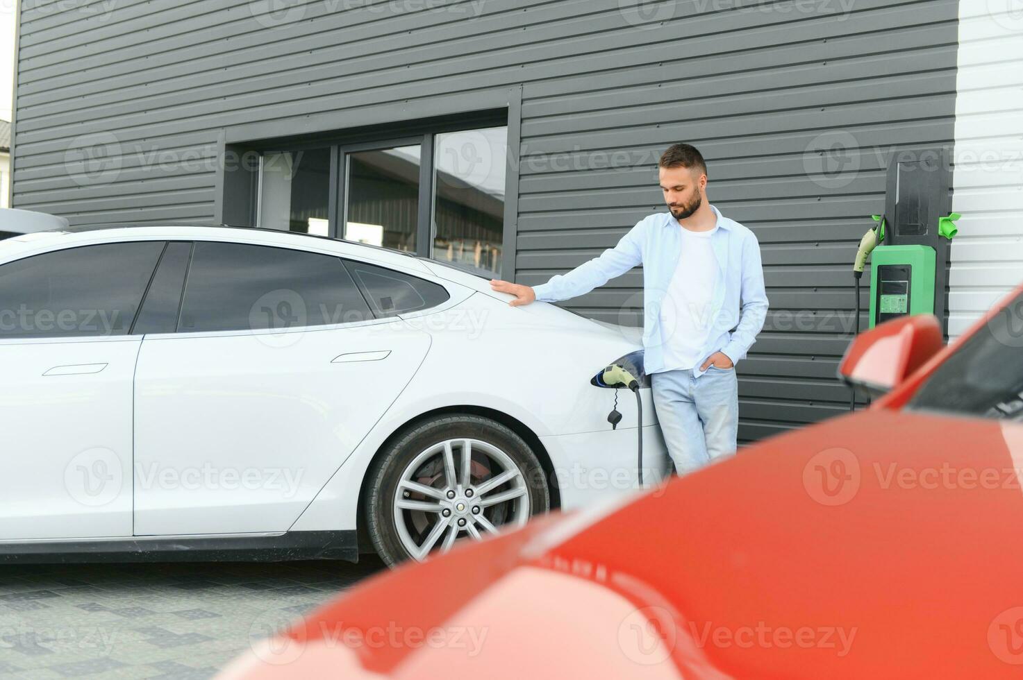 Man standing by his electric car photo