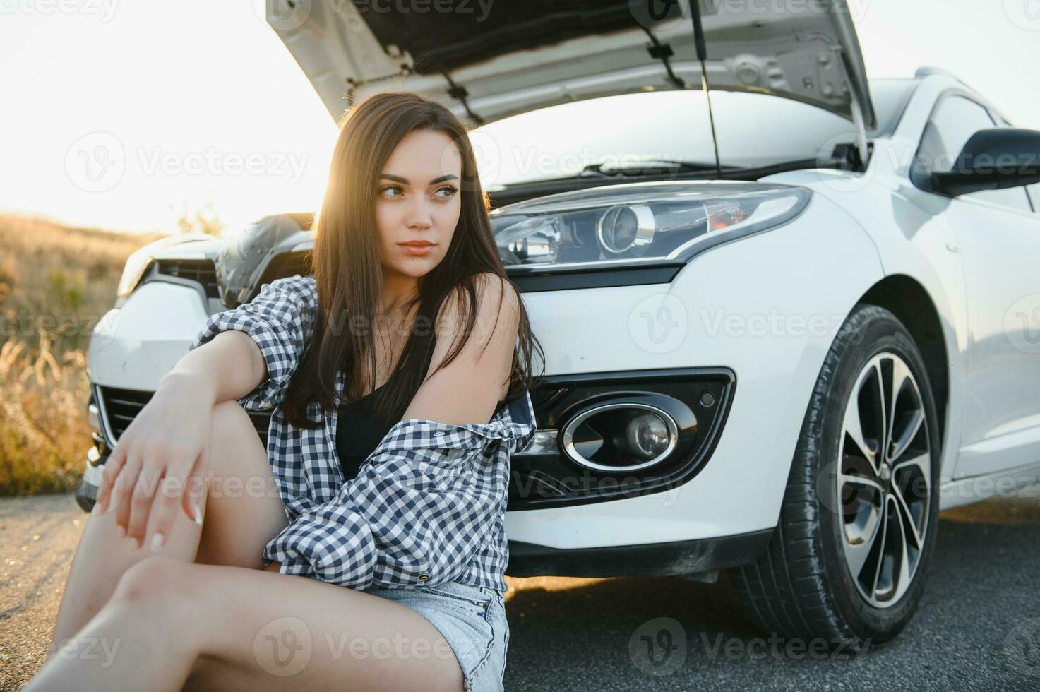 hermosa sexy mujer cerca un roto coche. confuso mujer lo hace no saber qué a hacer foto