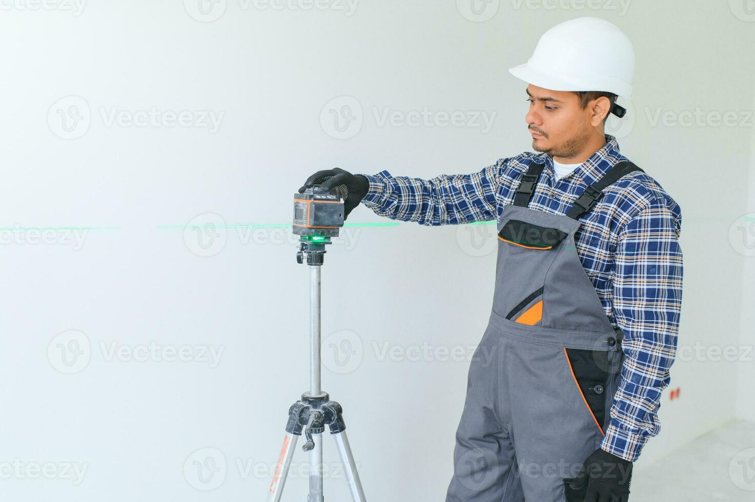 Indian worker makes repairs in an apartment photo