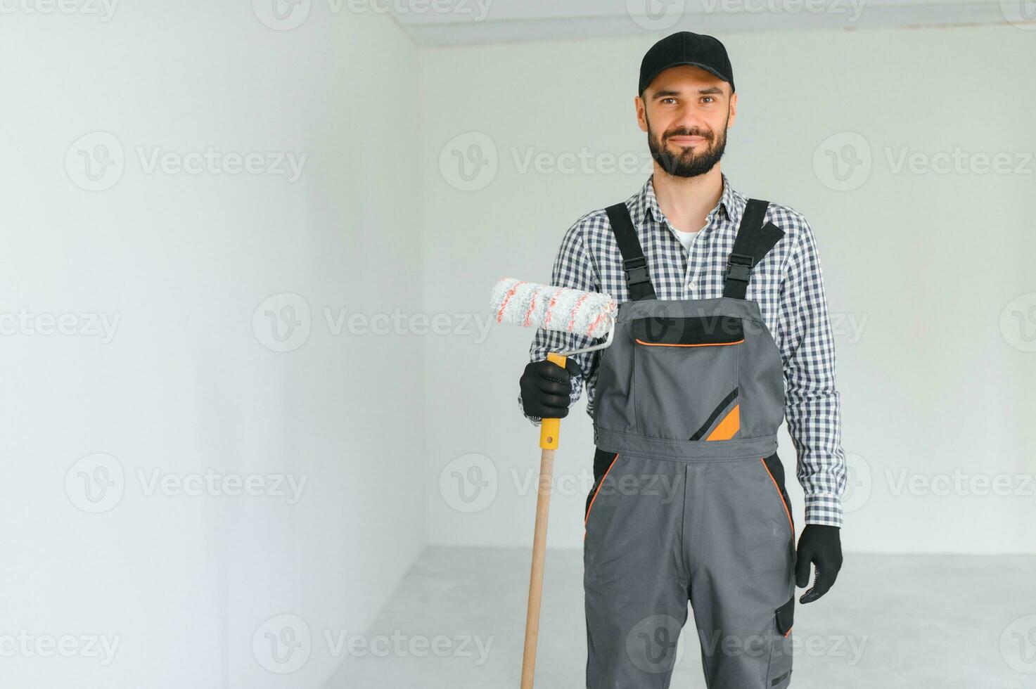 joven trabajador pintura pared en habitación. foto