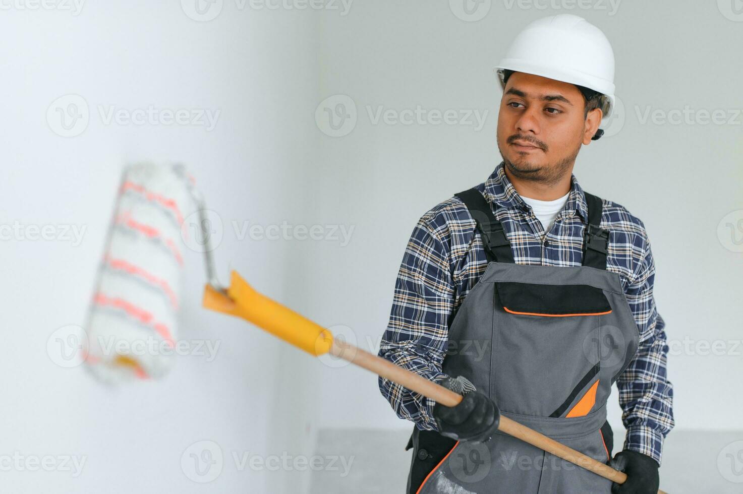 Indian worker makes repairs in an apartment photo