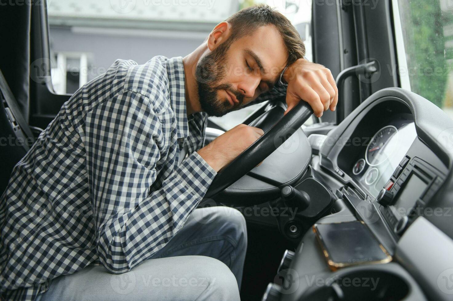 Man trucker tired driving in a cabin of his truck photo