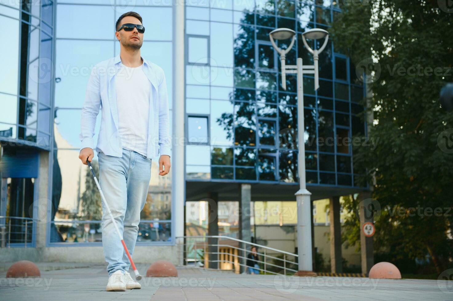 Blind man. Visually impaired man with walking stick, photo