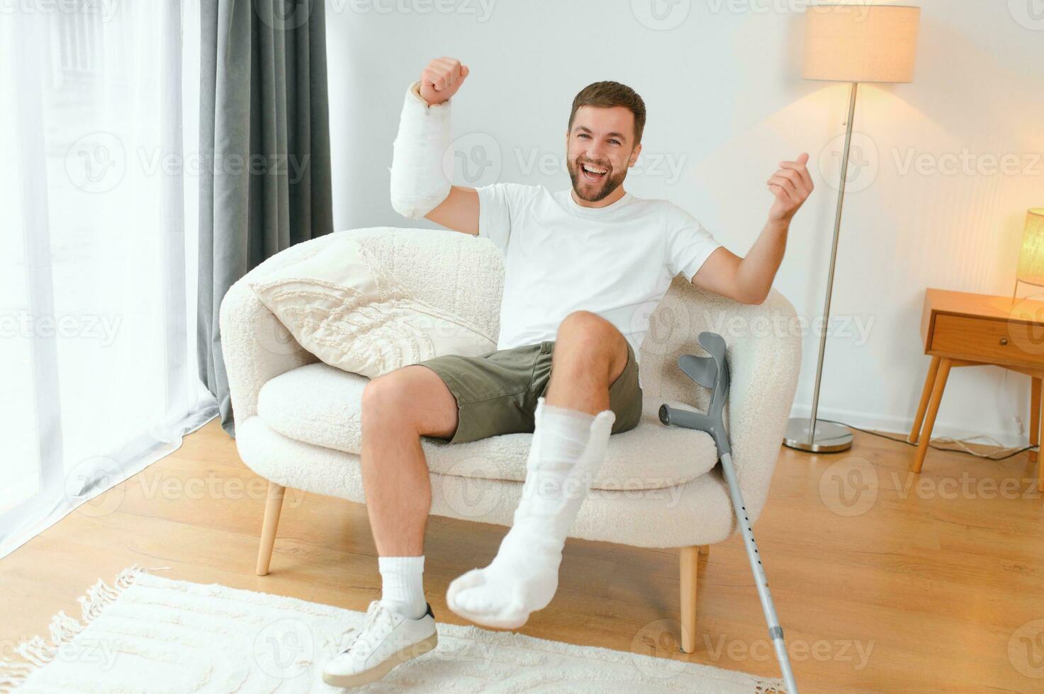 Happy man recovery from accident fracture broken bone injury with leg and arm. Social security and health insurance concept photo