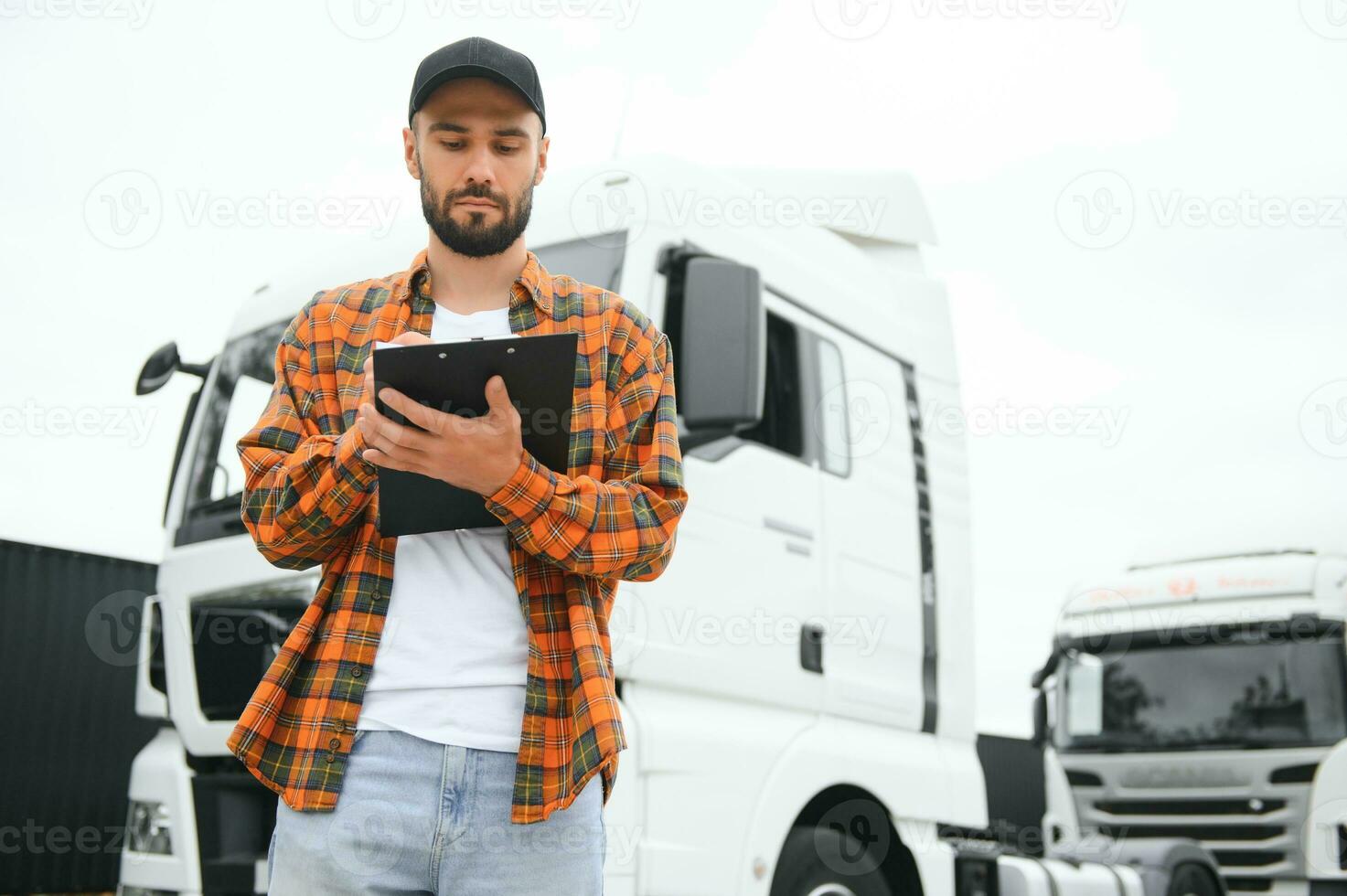 Male driver with clipboard near big truck outdoors photo